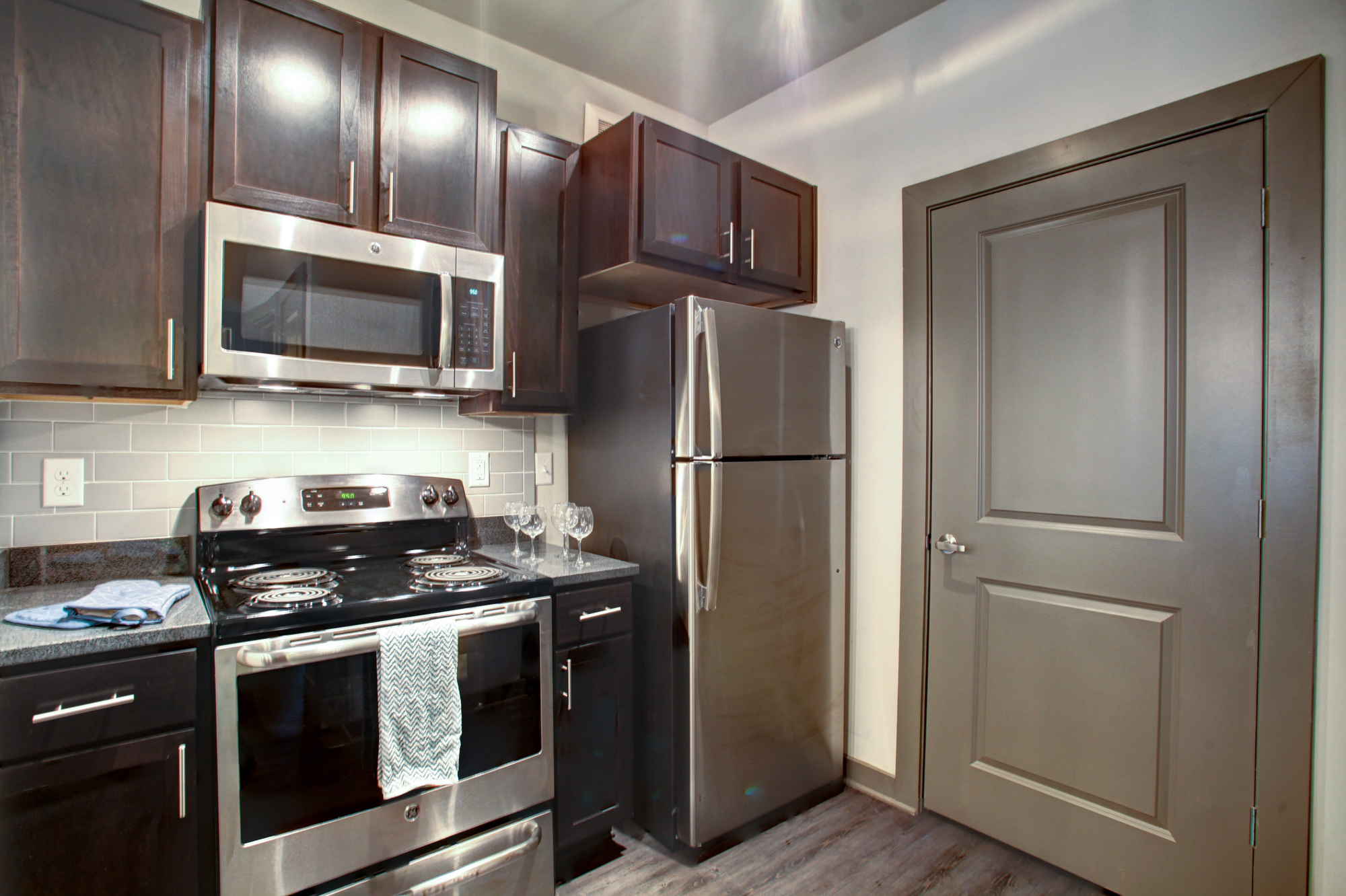Espresso cabinetry with brushed nickel pulls and stainless steel appliances are in the kitchen at Park 9 apartments.