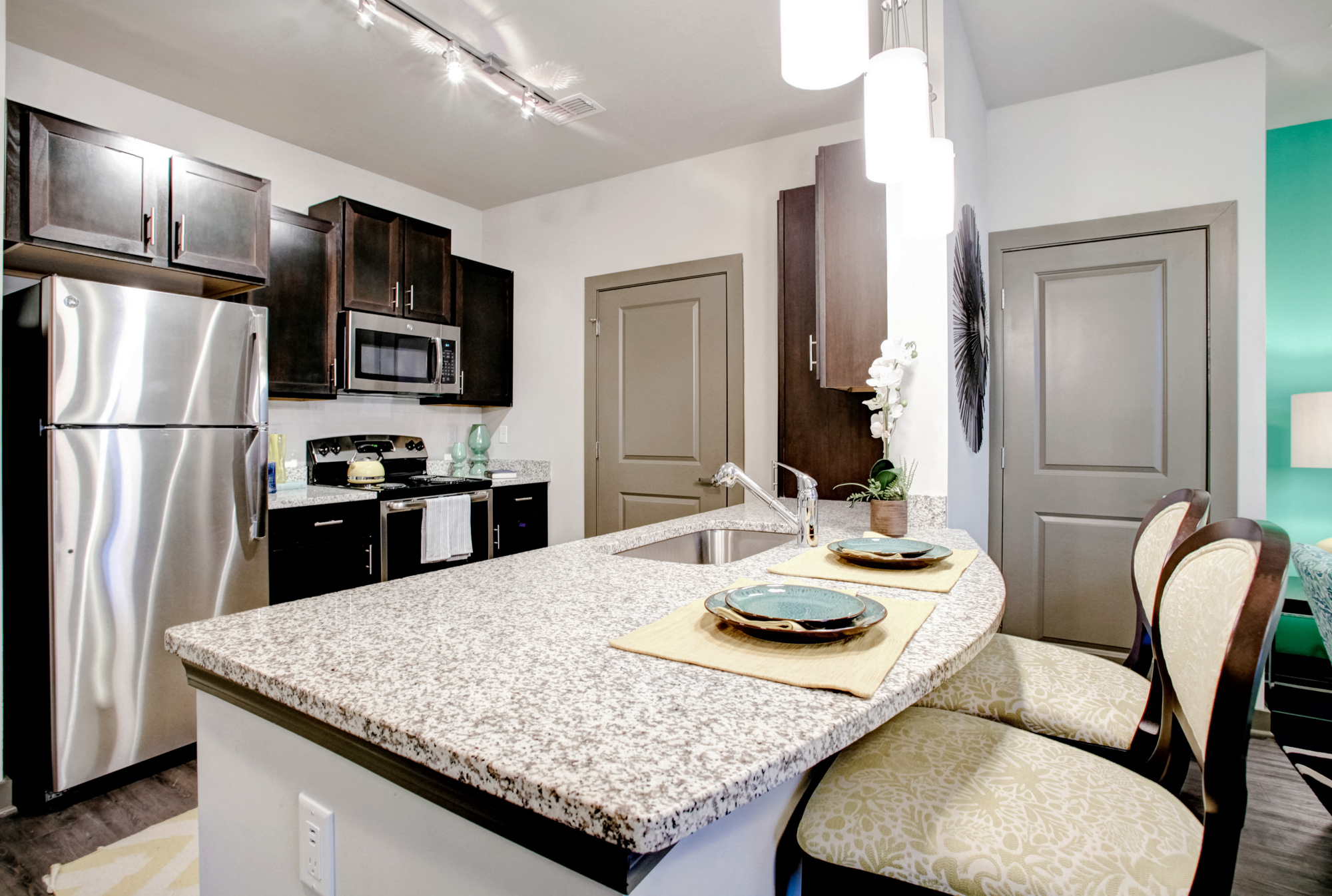 A kitchen with brown cabinets and stainless steel appliances at Park 9 apartments near Atlanta, GA.