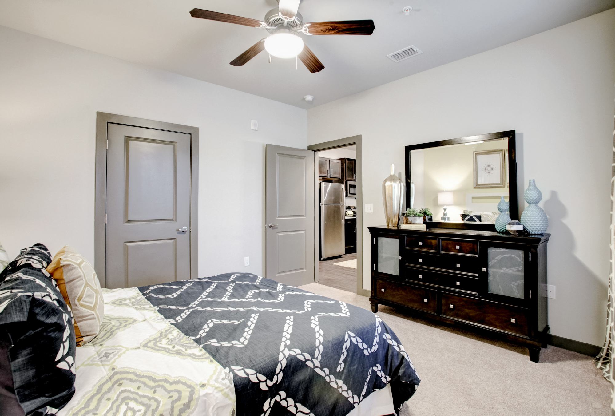 A bed and dresser are in the bedroom at Park 9 apartments in Woodstock, GA.