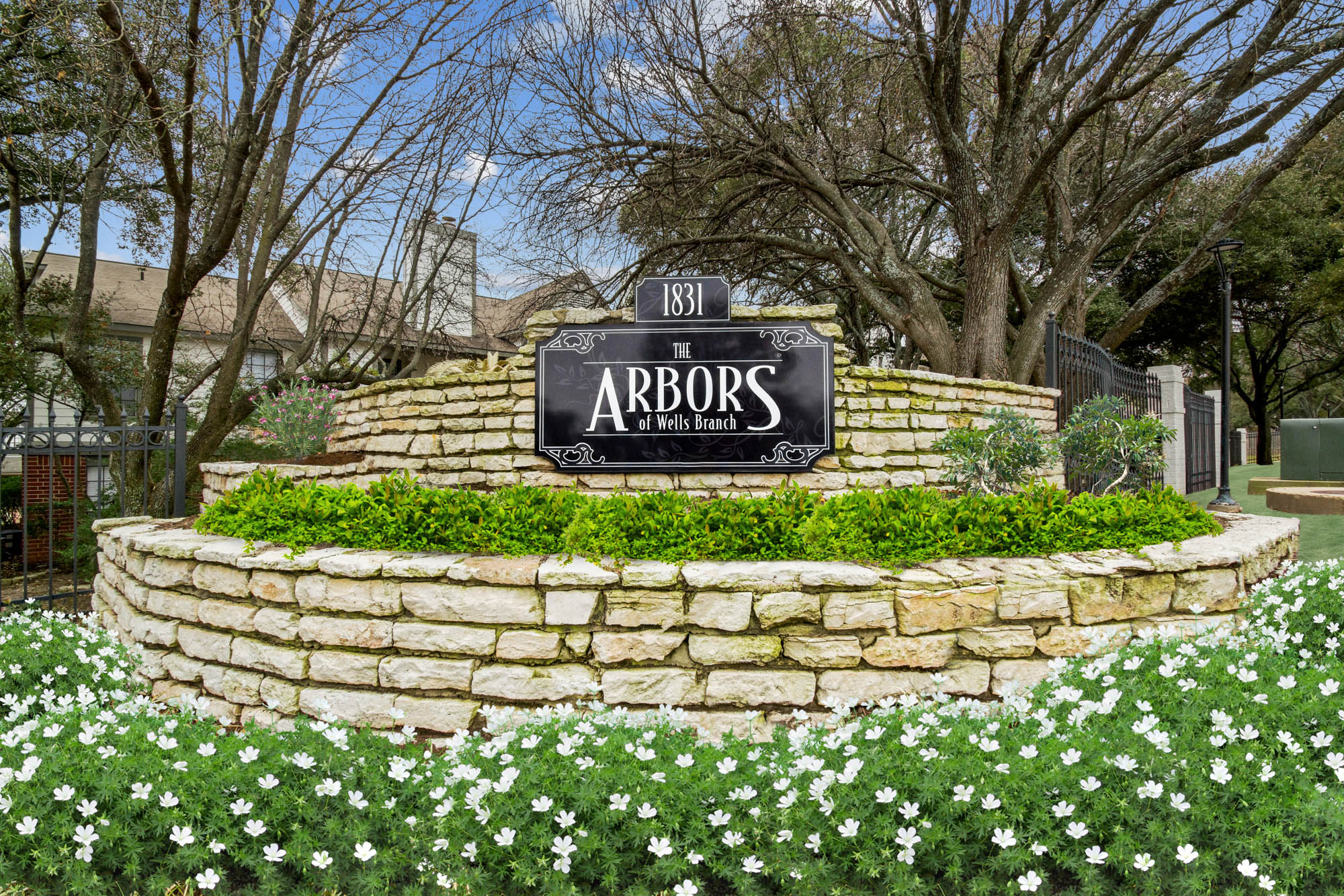 The main entrance sign at The Arbors of Wells Branch apartments in Austin, TX.